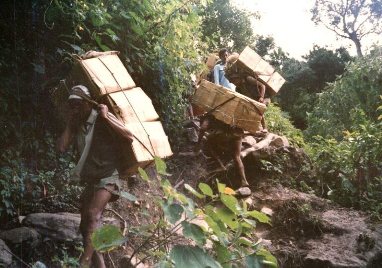 photo porters carry truck cargo on their backs after a landslide stops traffic