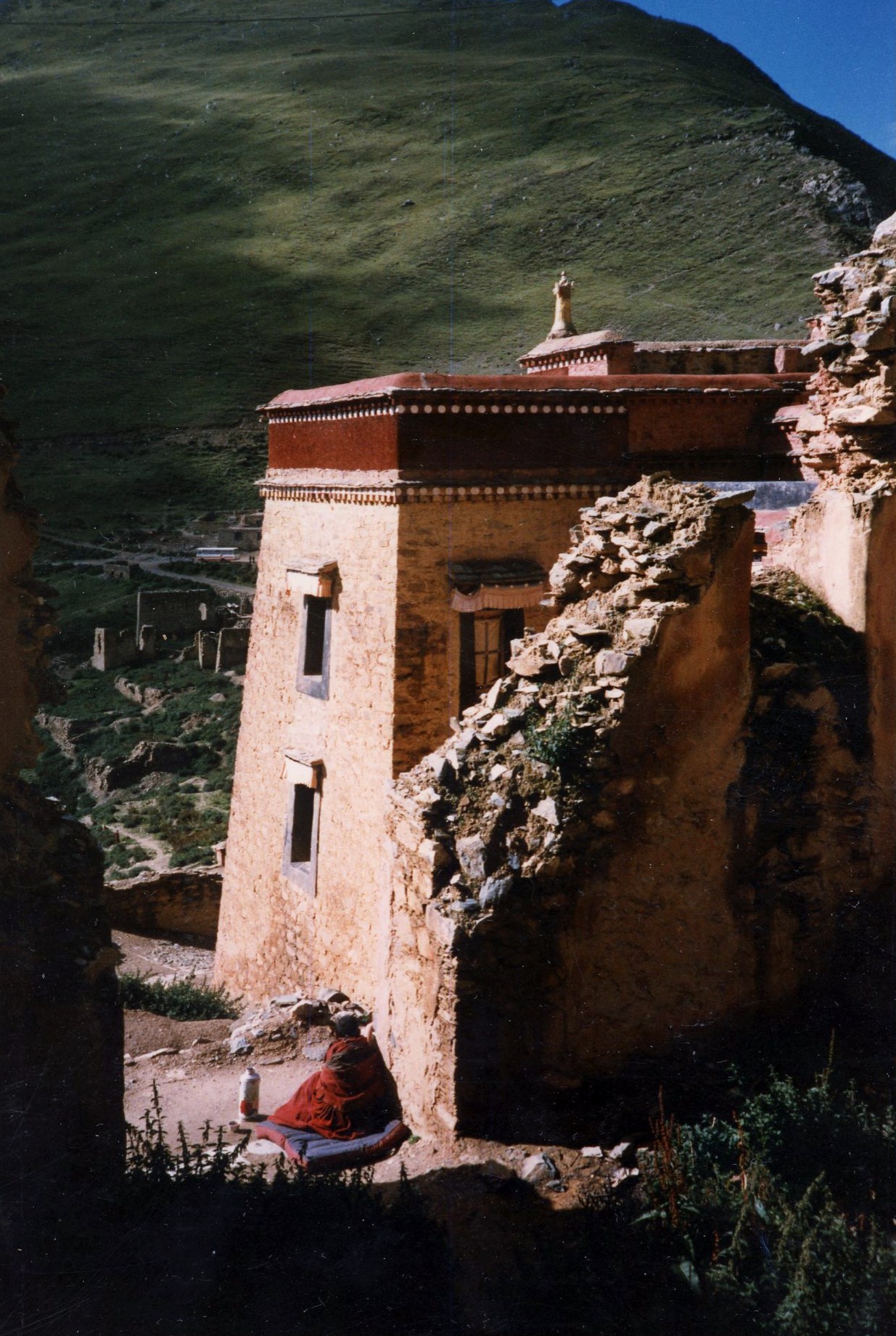 Photo of Monk meditating outside Ganden monastery outside